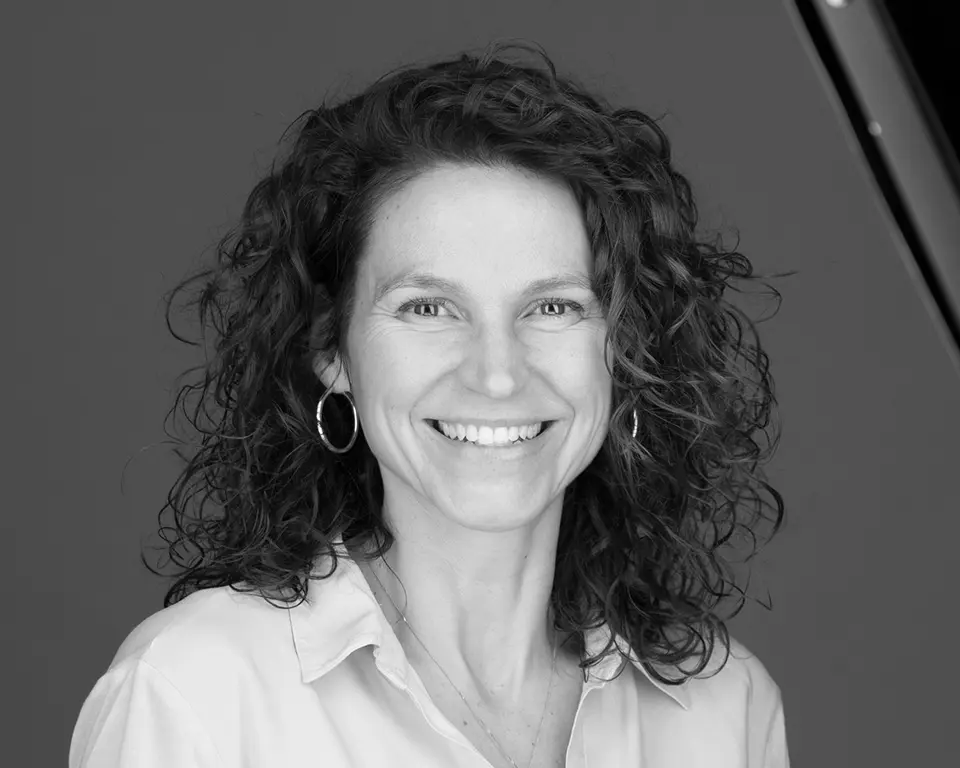 A woman with curly hair smiling for the camera.