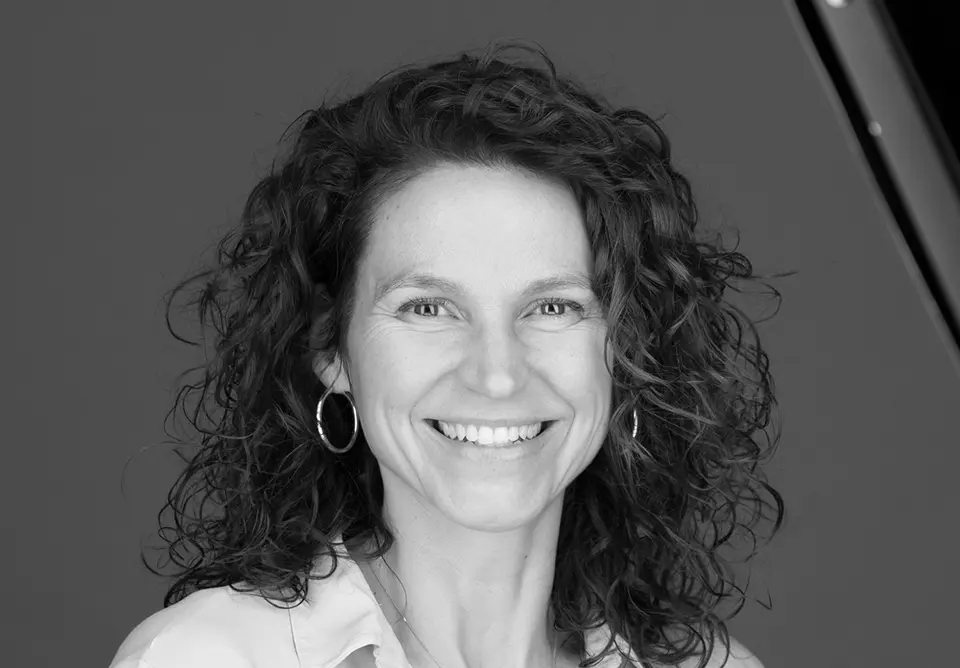 A black and white photo of a woman smiling.